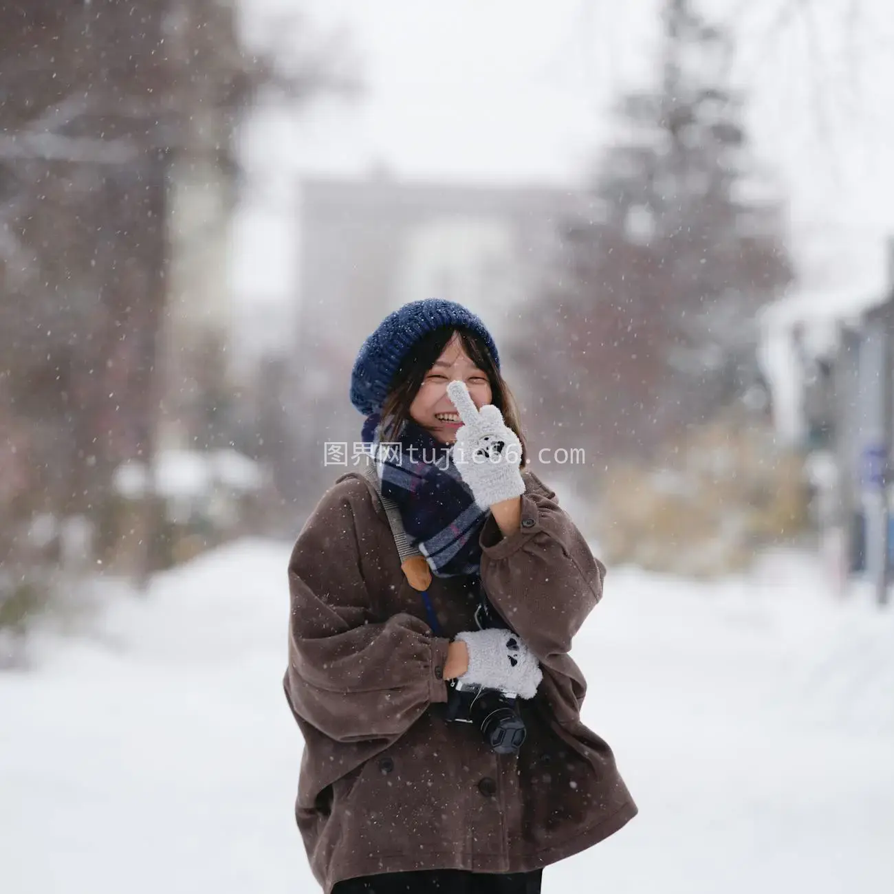 微笑女性户外摄影手套享雪景图片