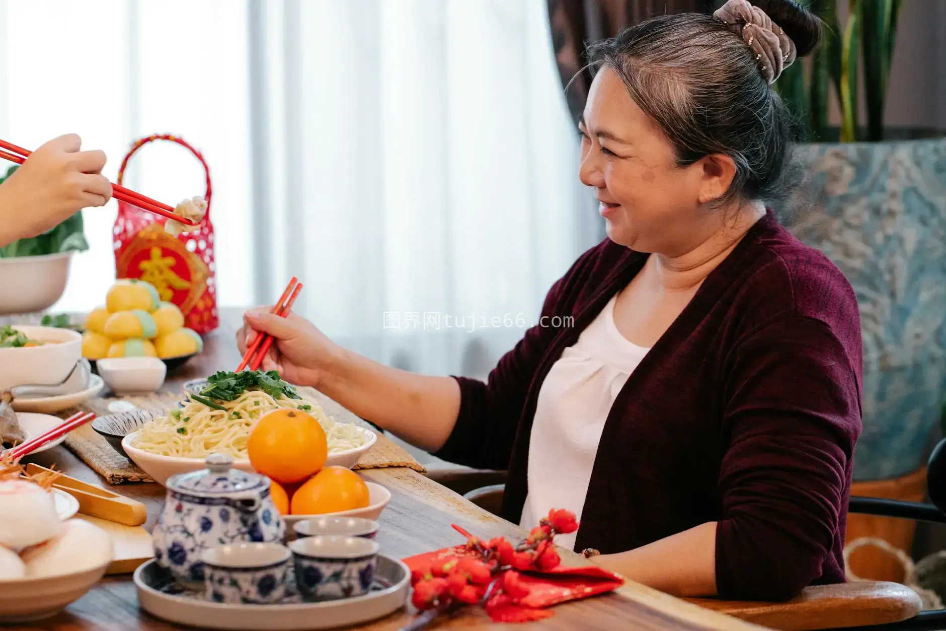 新年餐桌少数民族女性与模糊亲戚共品面食图片