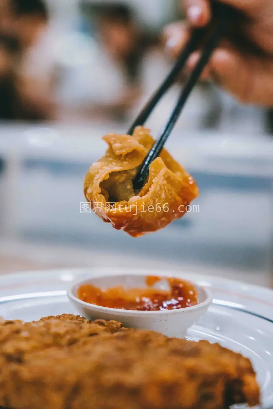 筷子夹饺子蘸酱特写呈现亚洲美食魅力图片