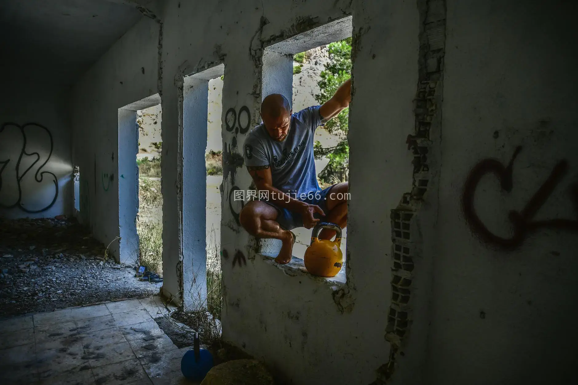 废弃涂鸦建筑男子壶铃锻炼图片