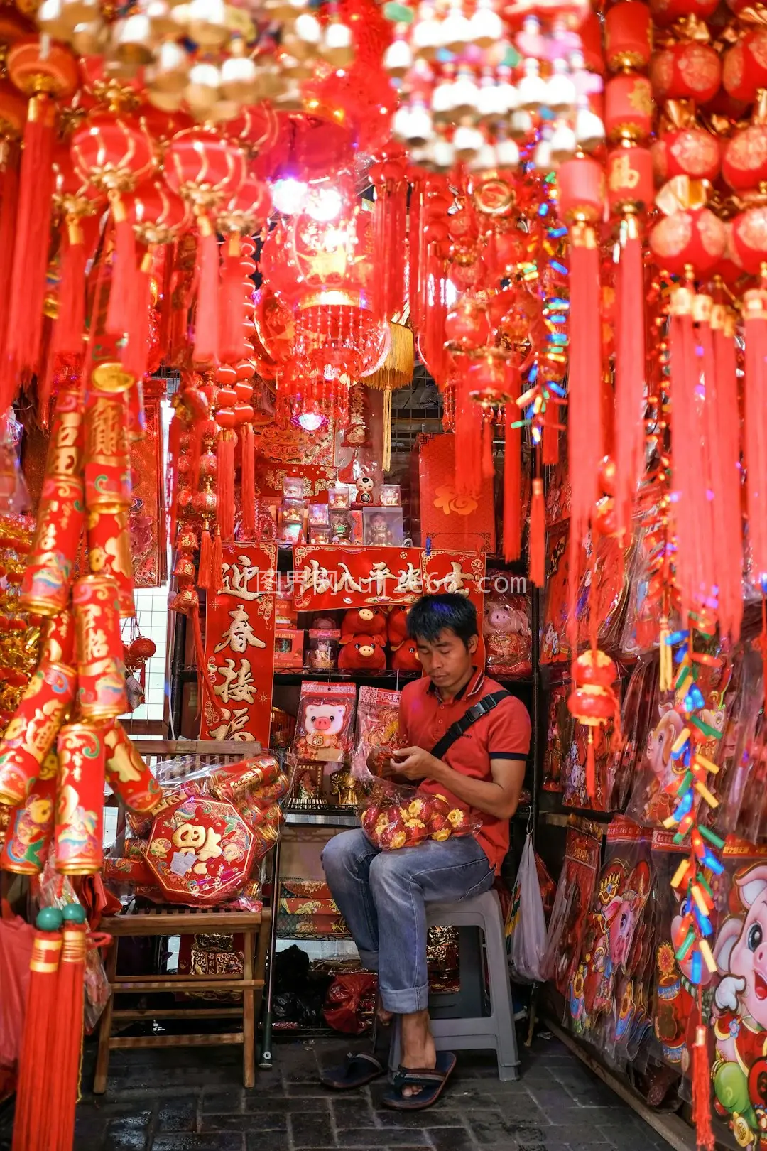 男士蓝裤灯笼店前坐图片