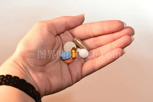 特写手握多彩药片图