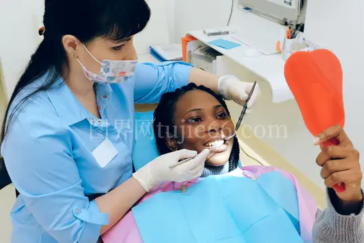 女性牙医细查患者口腔