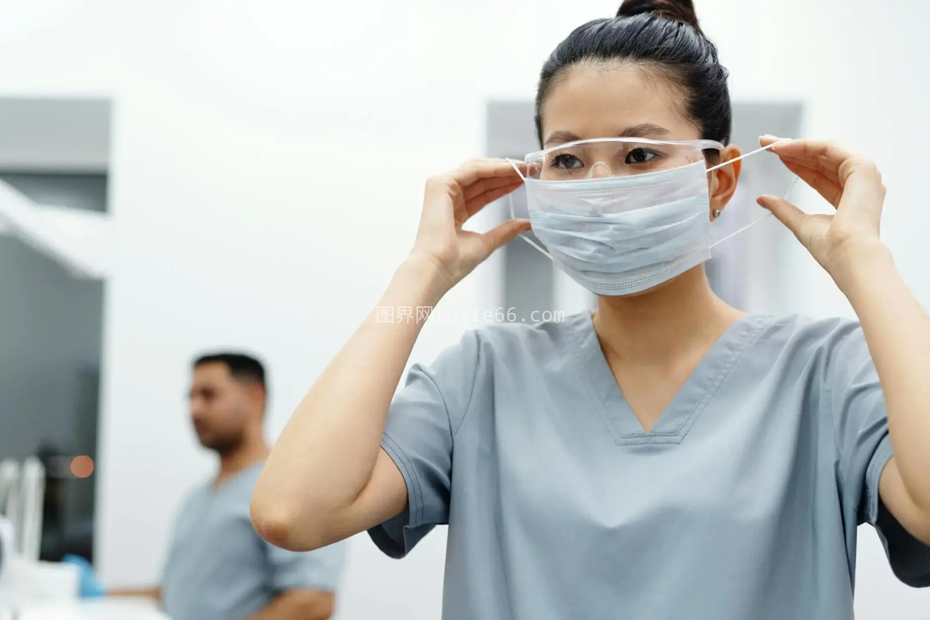 亚洲女医护调整防护装备图片