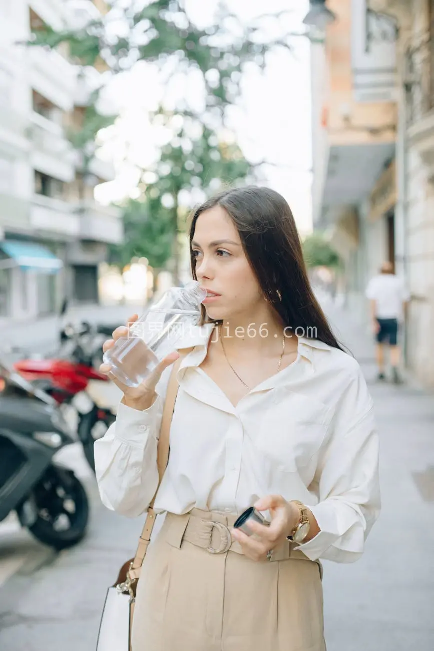 时髦女性街头品水图片