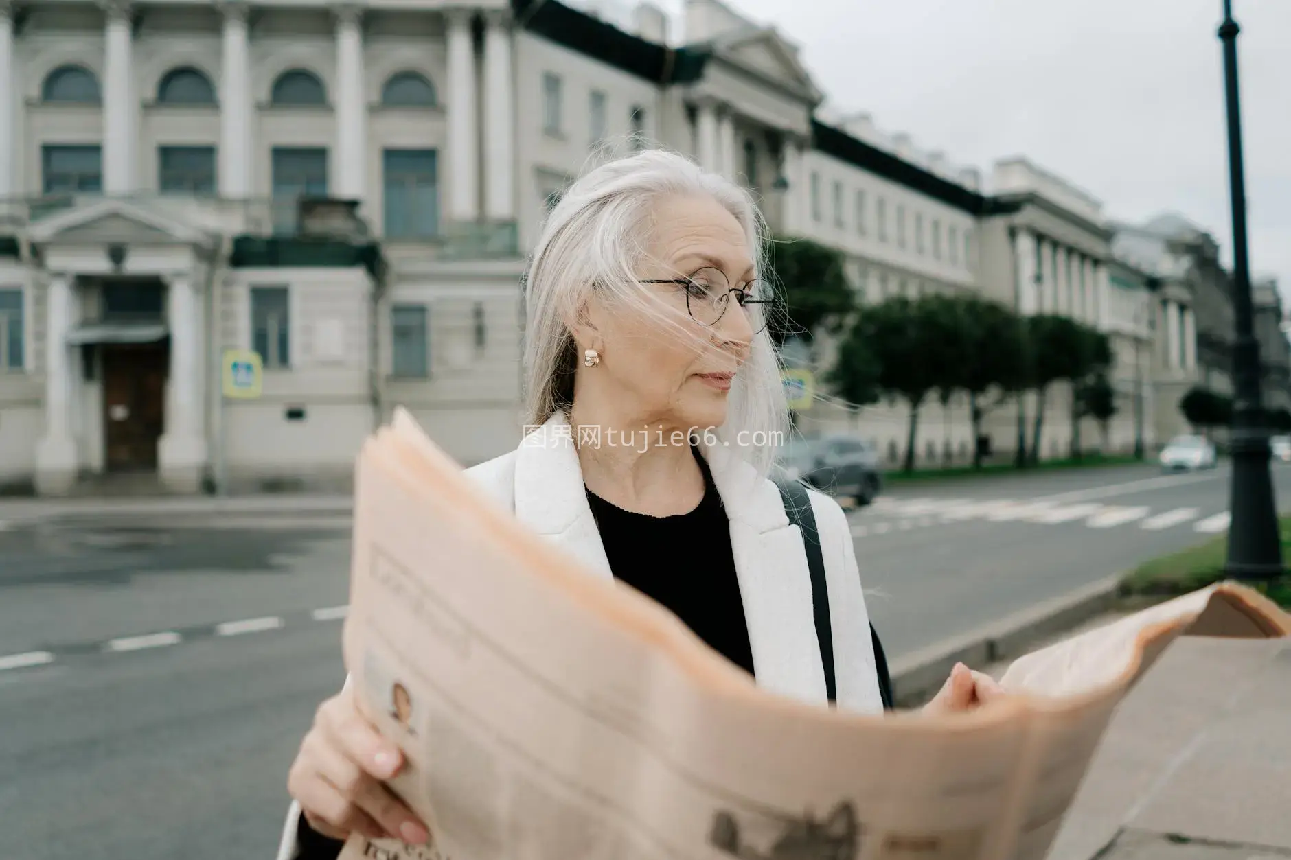 白发老妇街头读报图片