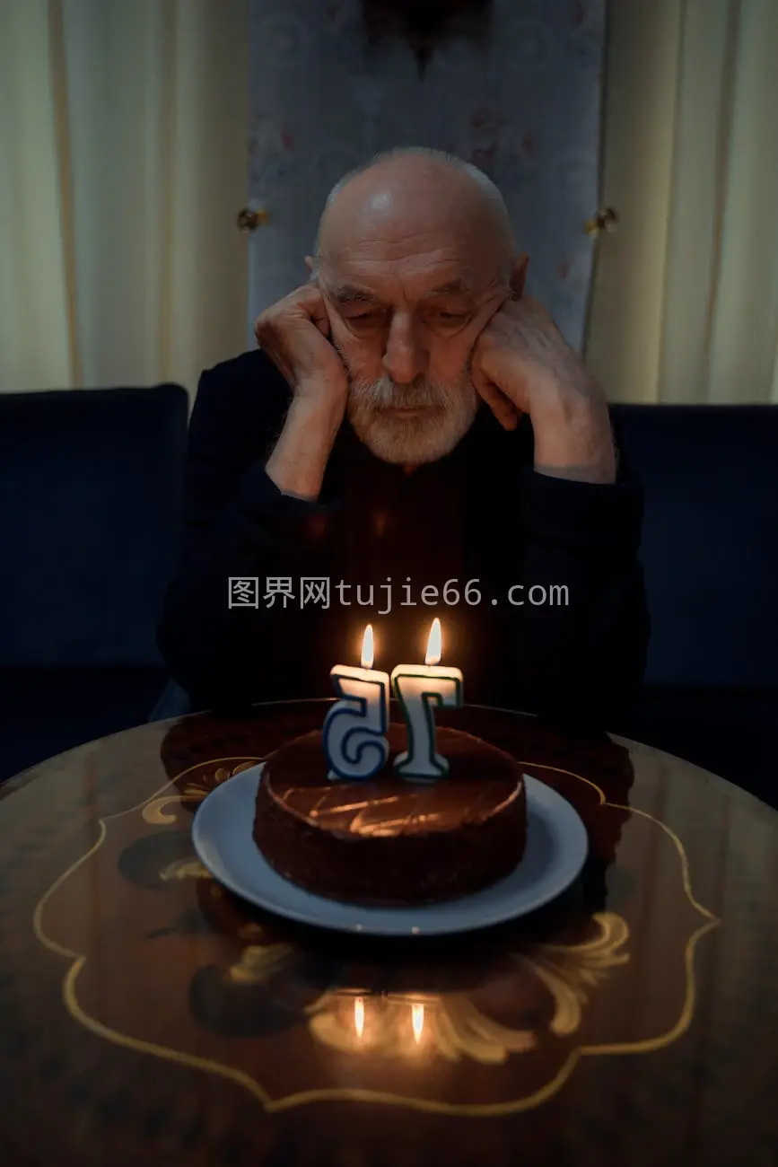 老人独享生日蛋糕沉思烛光图片