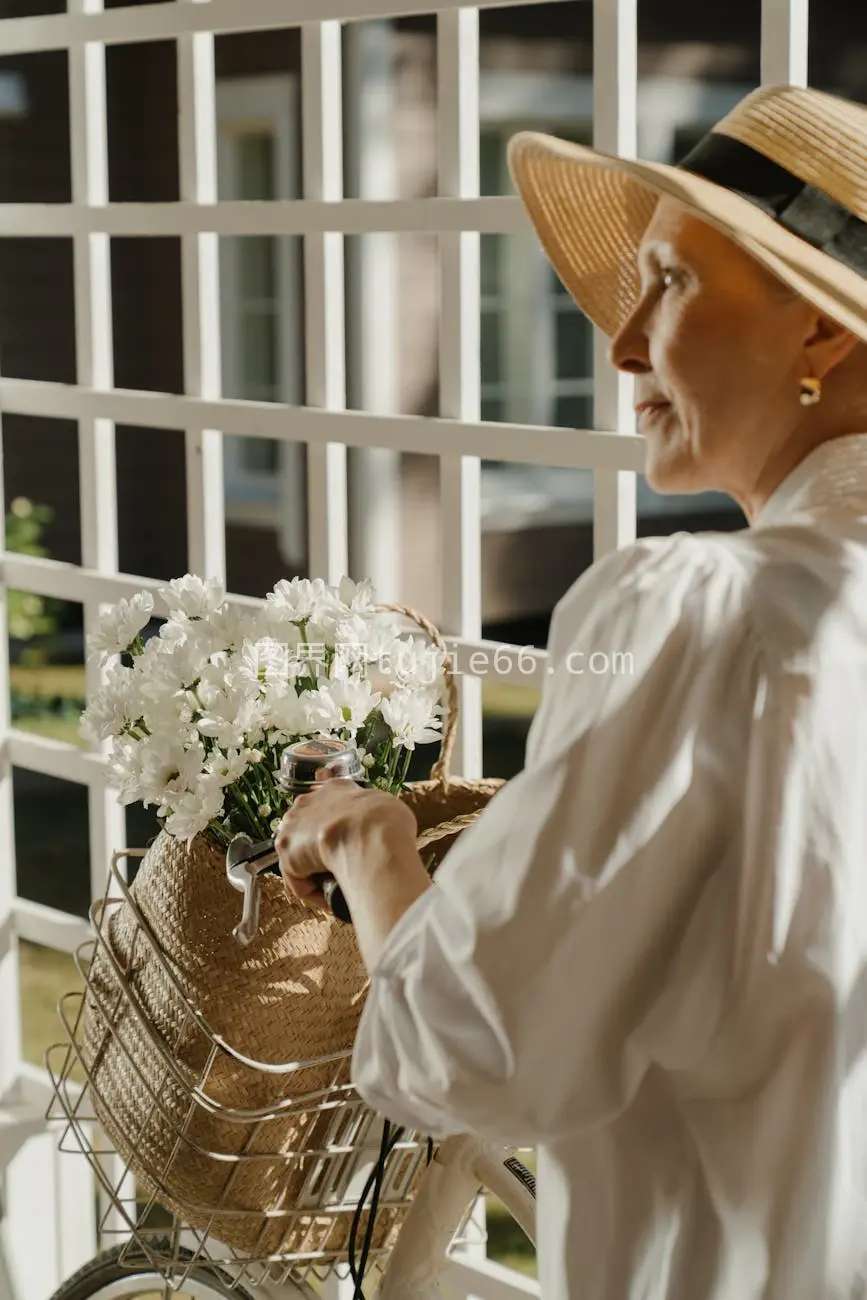 年长女士草帽自行车白花户外图片