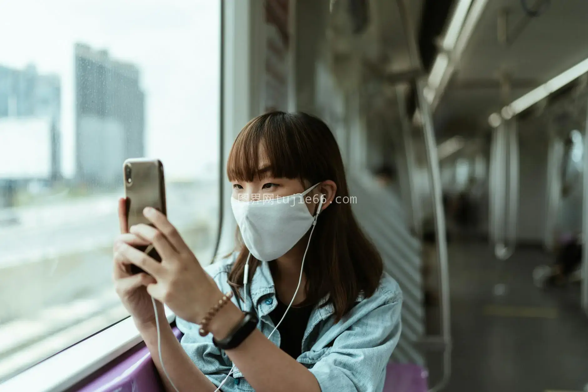 戴口罩女子地铁玩手机图片