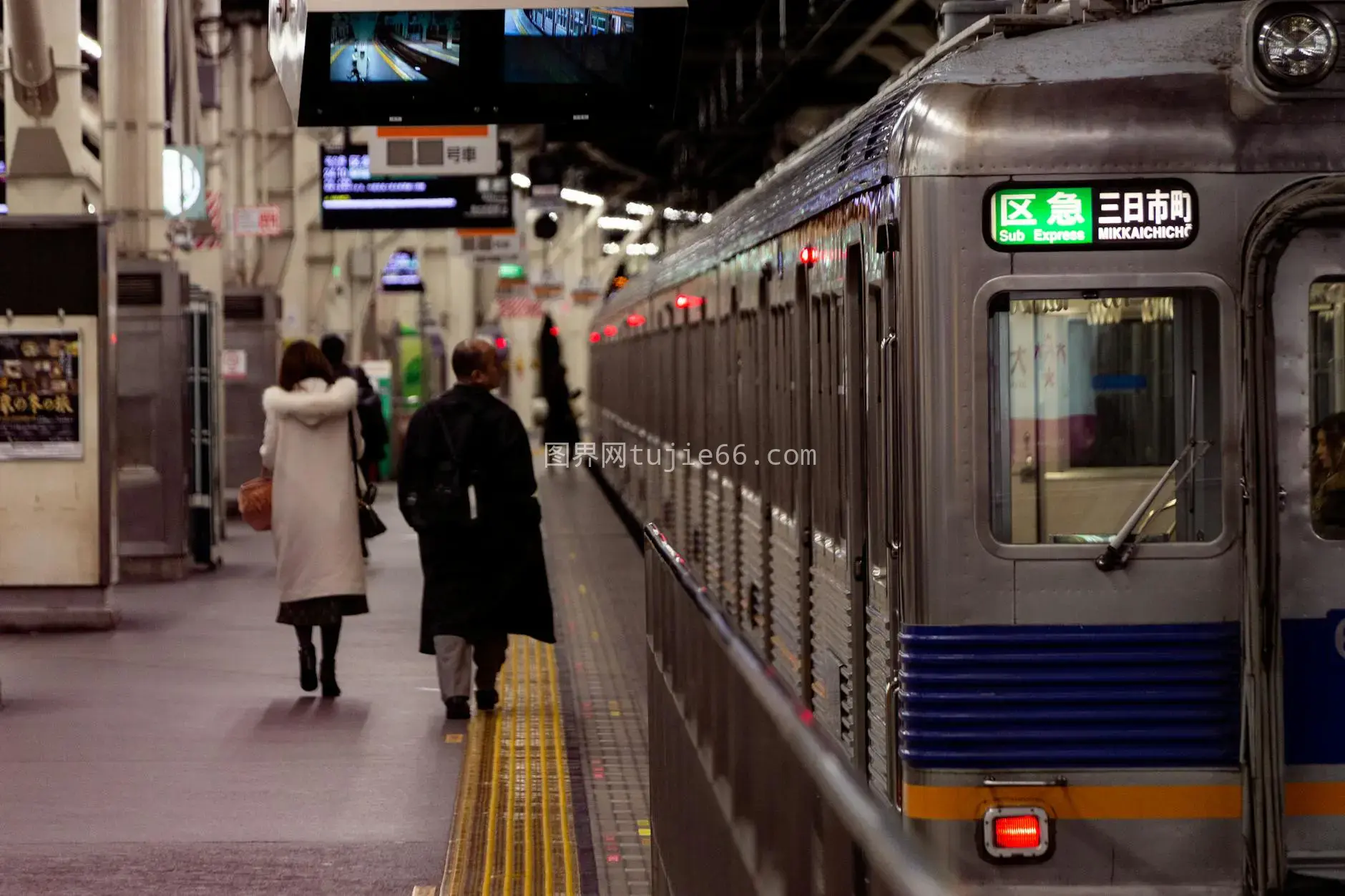 Osaka火车站站台上通勤者与高速列车图片