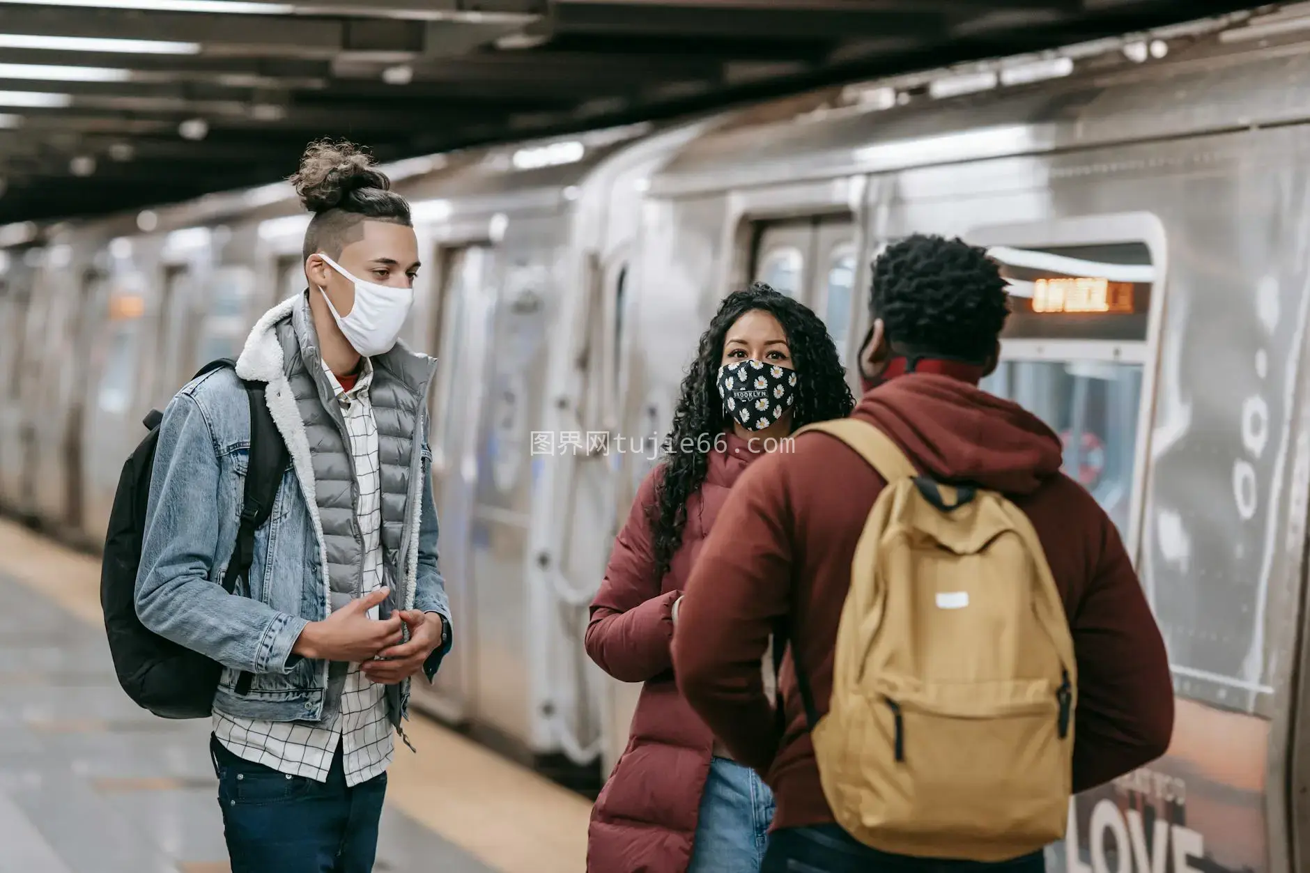 地铁里戴口罩年轻人交谈图片