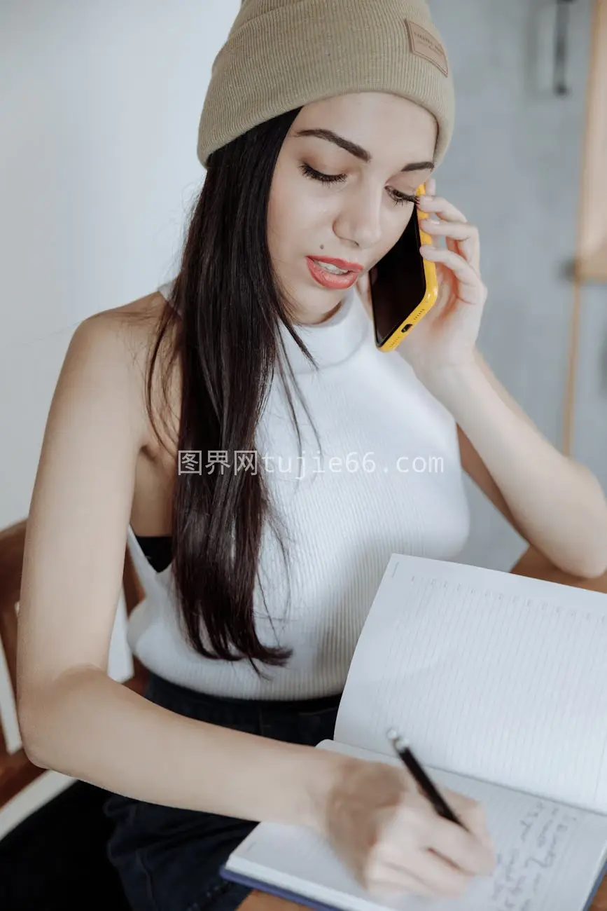 年轻女性通话记笔记显高效多任务图片