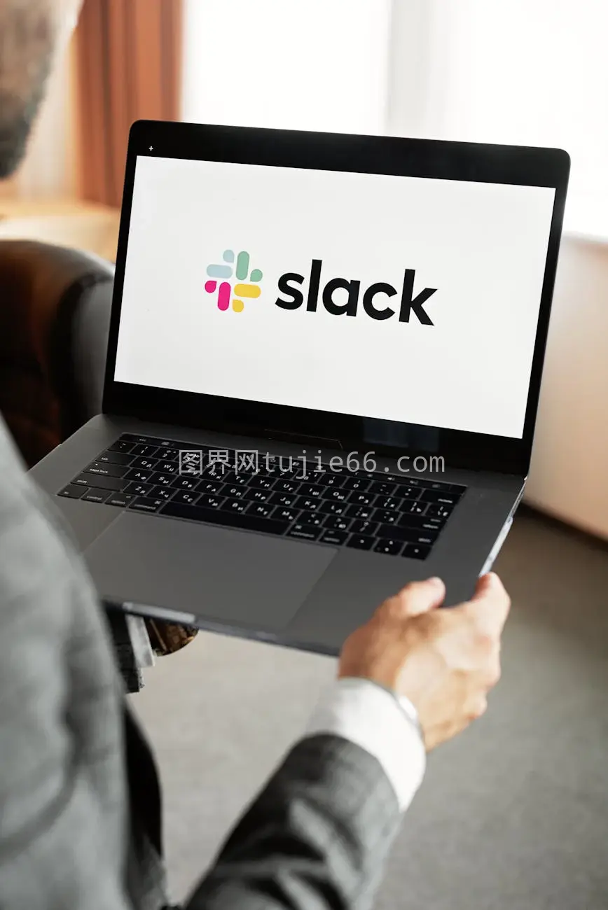 商人笔记本电脑用Slack现代通信图片