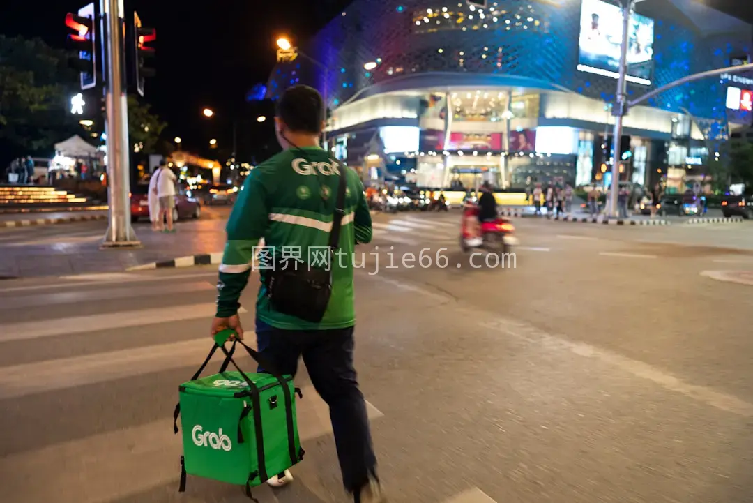 男子过马路手提绿袋图片