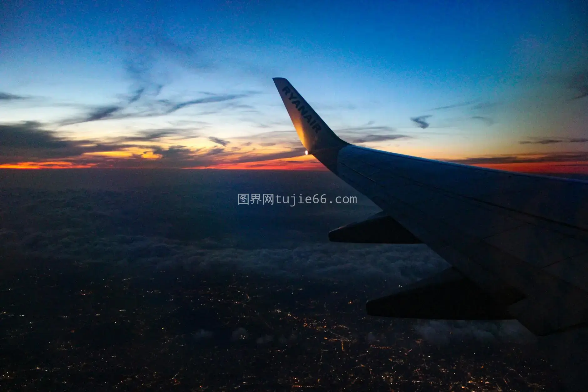 日落城市飞机翼映衬绚烂天空图片