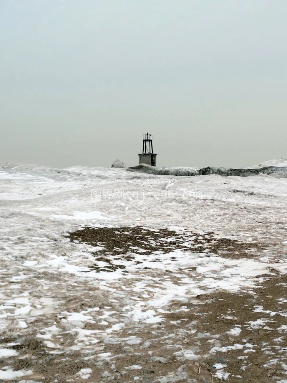 雪景海岸孤灯塔映衬冬夜图片