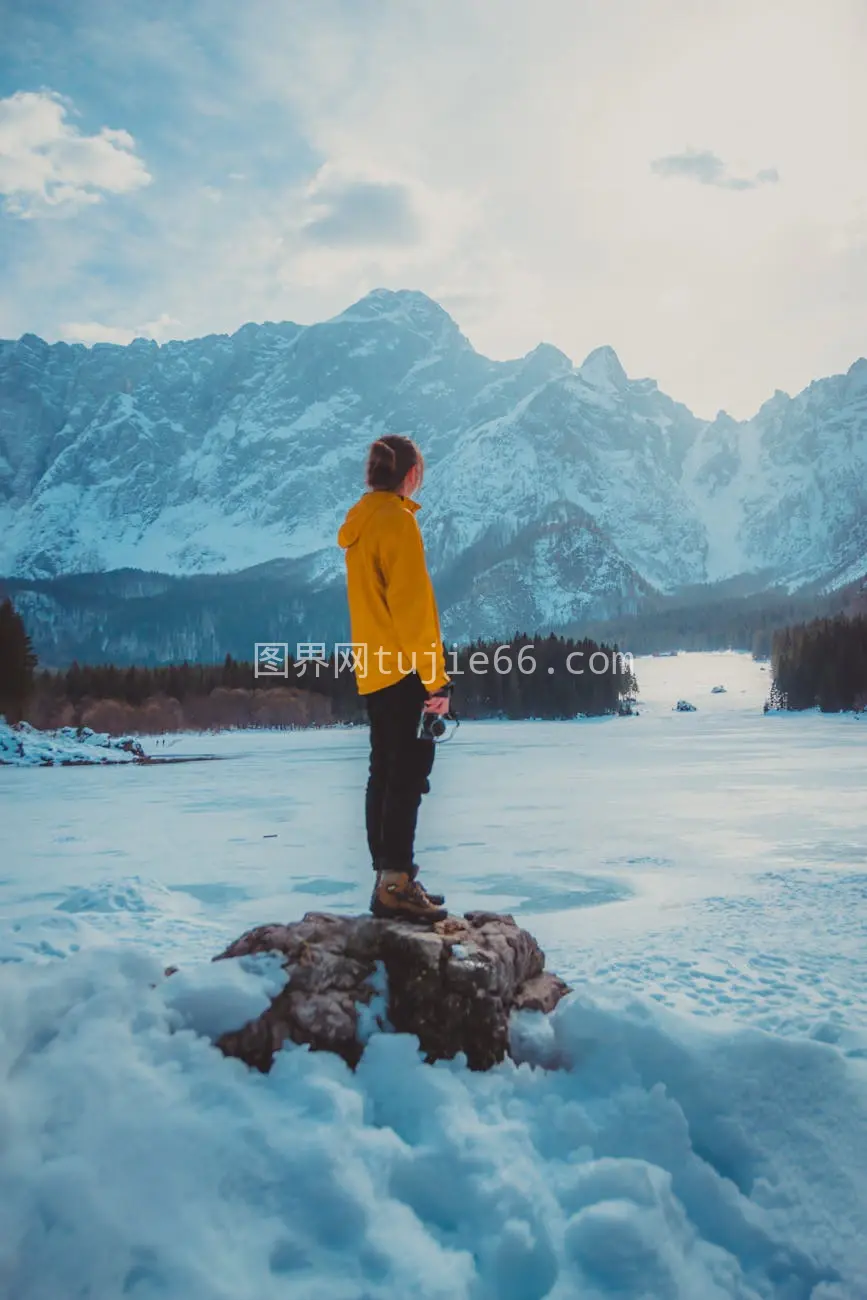 冬日雪景中黄色夹克欣赏山色图片