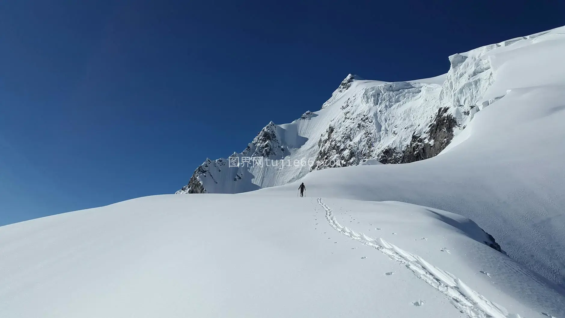 雪地徒步蓝天登山者独影图片