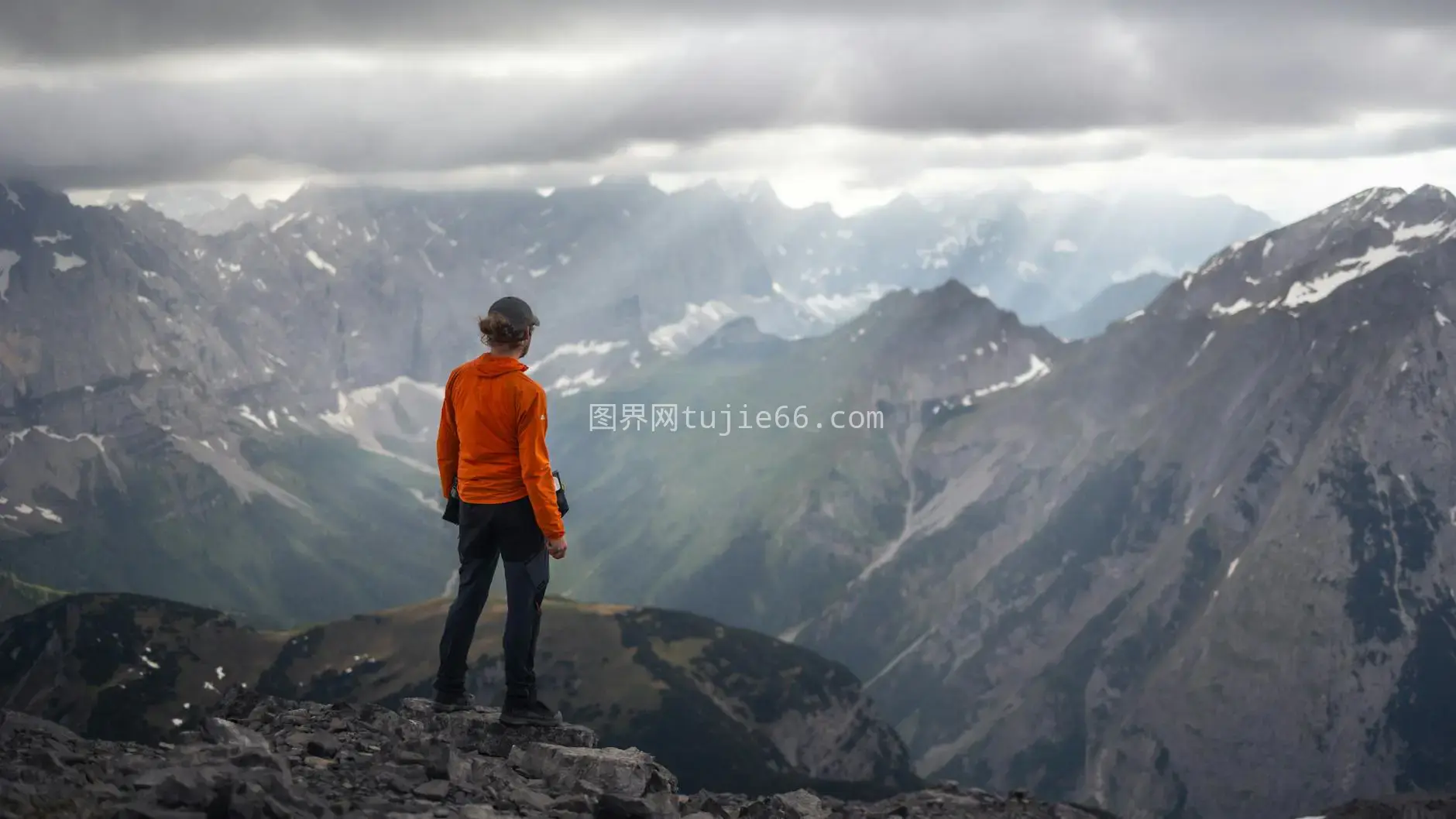 橙色夹克山顶观阿尔卑斯图片