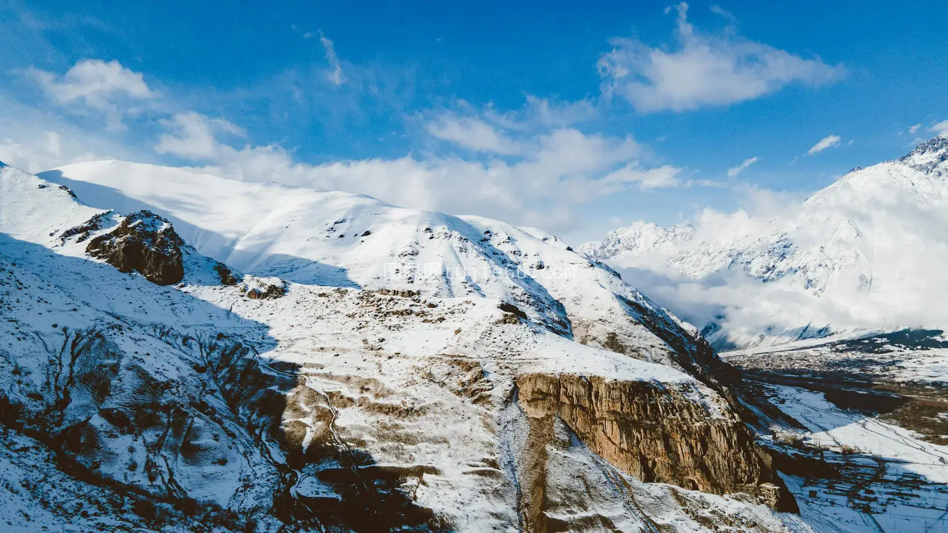 空中俯瞰壮丽雪山湛蓝天空图片