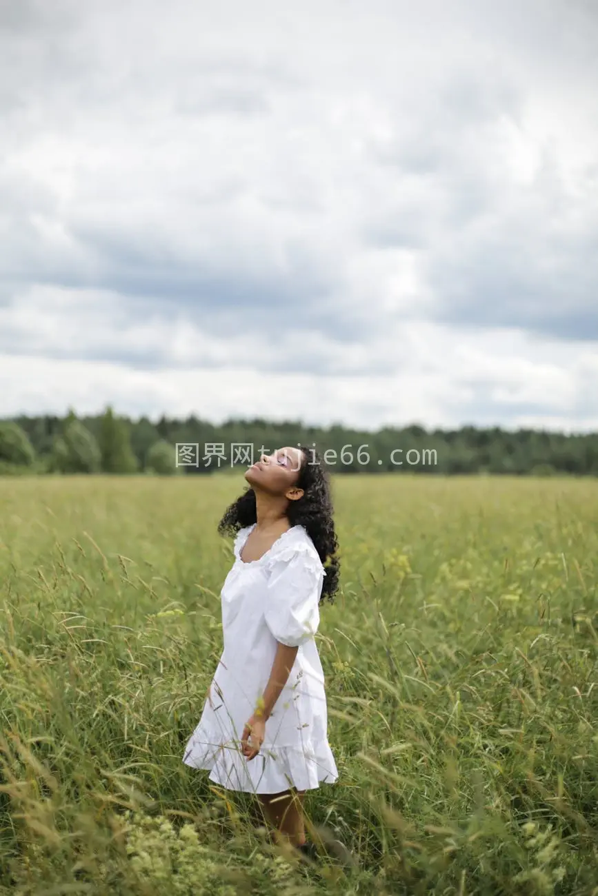 女士白裙绿草静享多云时图片