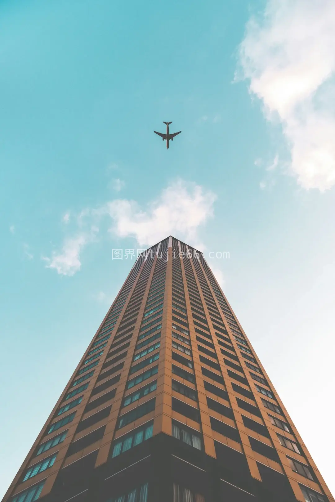 飞机高层建筑上空俯瞰飞行照图片