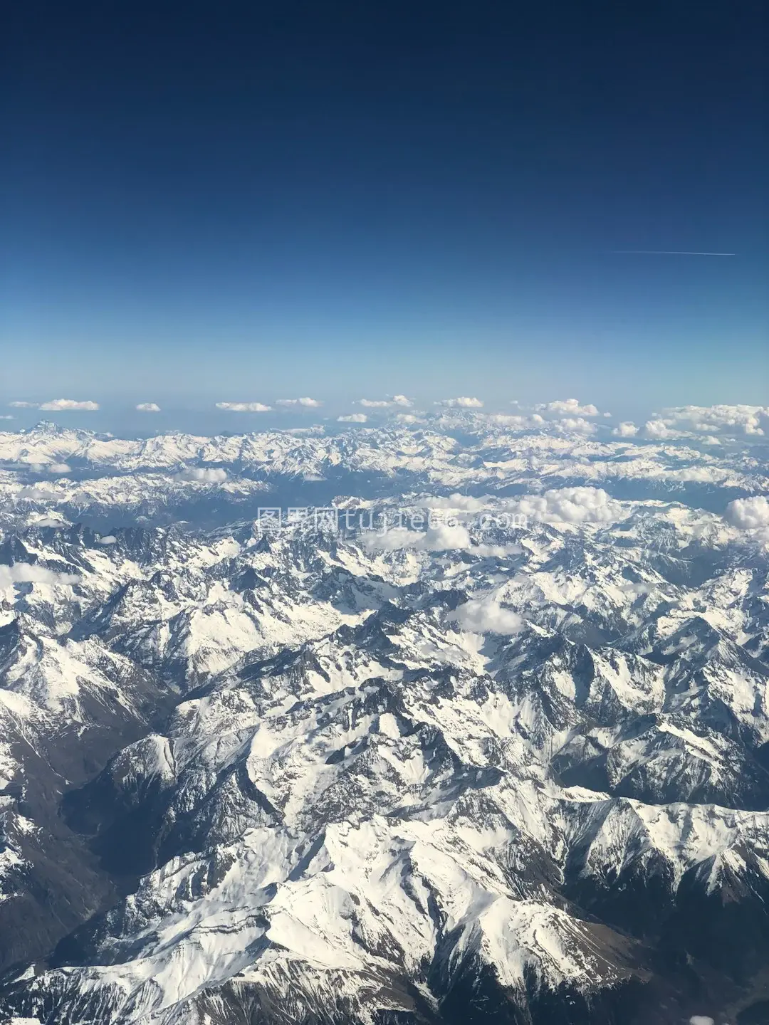 蓝天映衬黑白山脉白昼景致图片