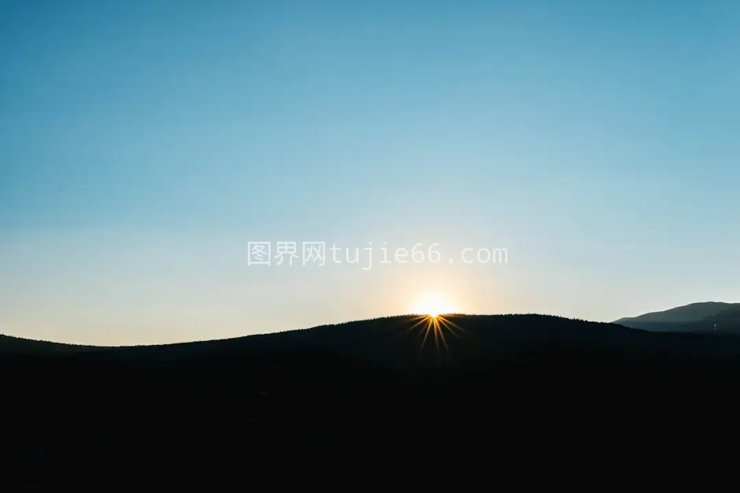 日落时分山脉映照太阳光芒图片