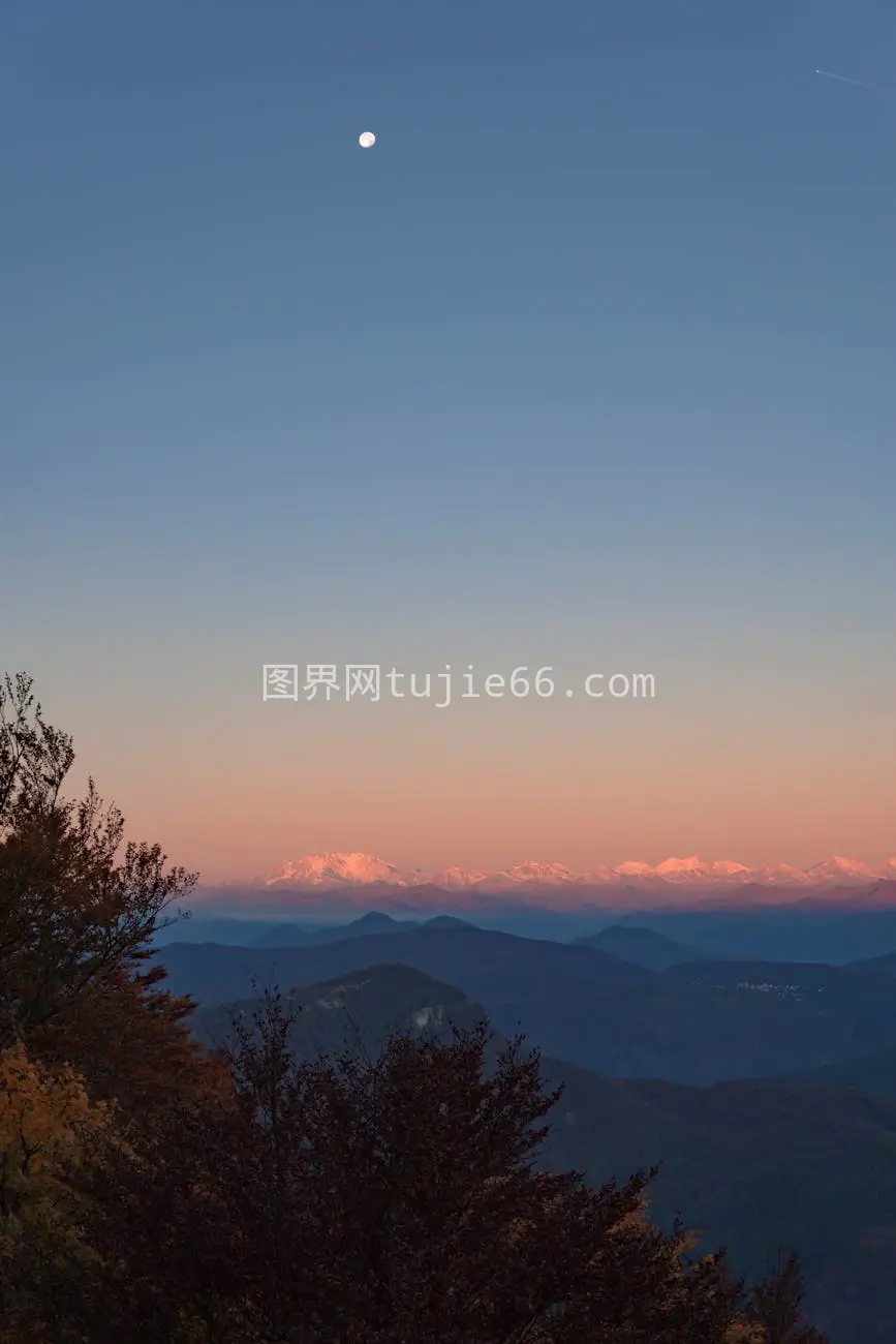 瑞士阿尔卑斯山日落晴空月影映照图片