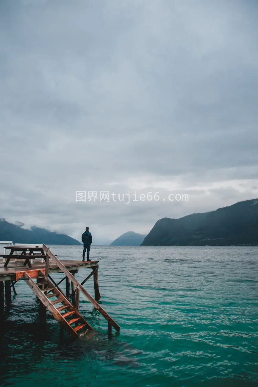 男性游客木质码头碧蓝海景模糊面容图片