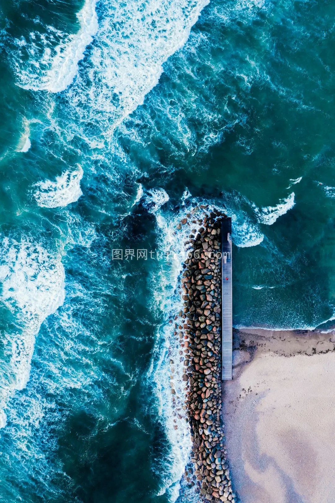 空中视角下日间海浪拍岸瞬间图片