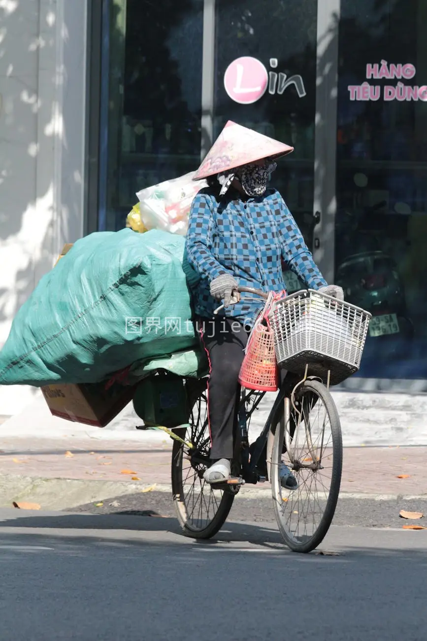 阳光中胡志明街头小贩载货骑行图片