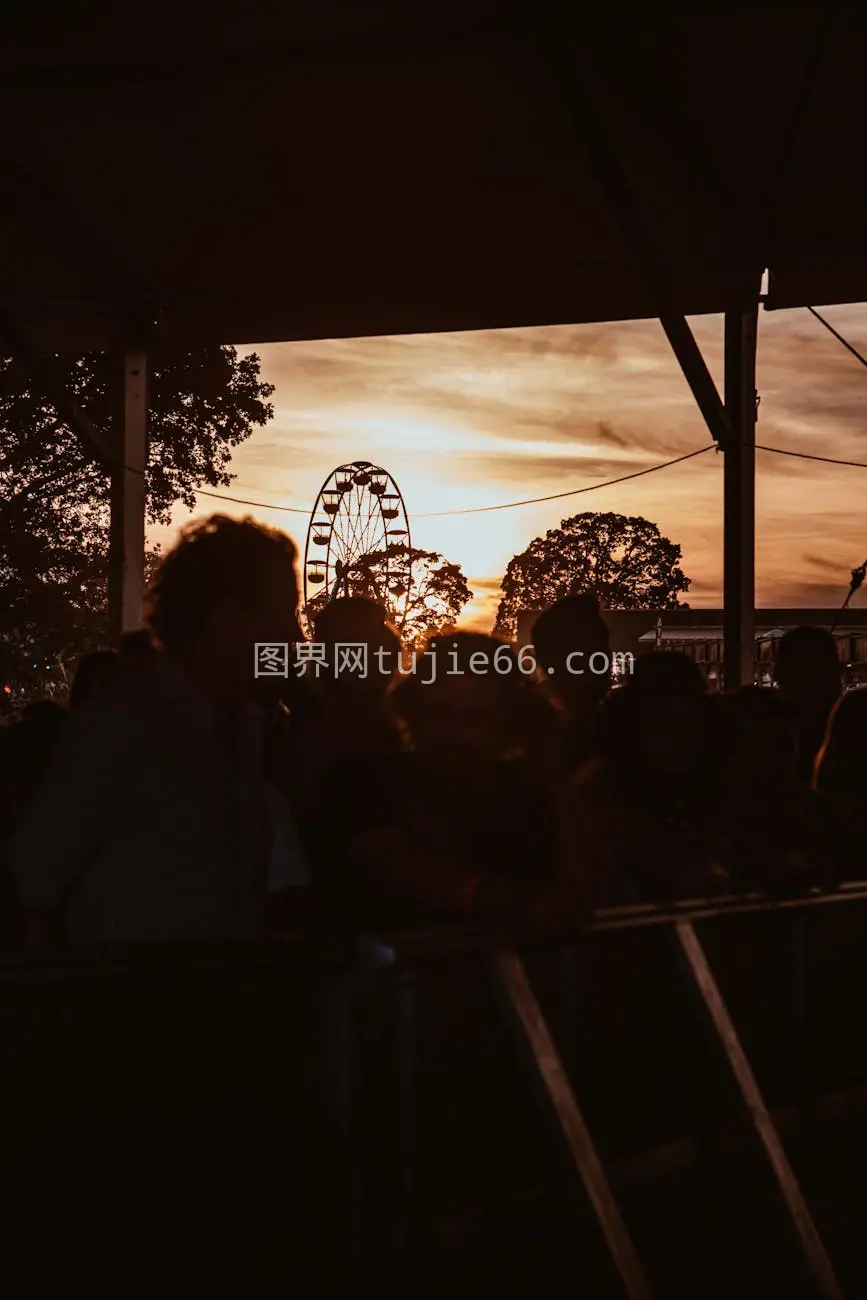 夕阳下节日人群剪影摩天轮图片