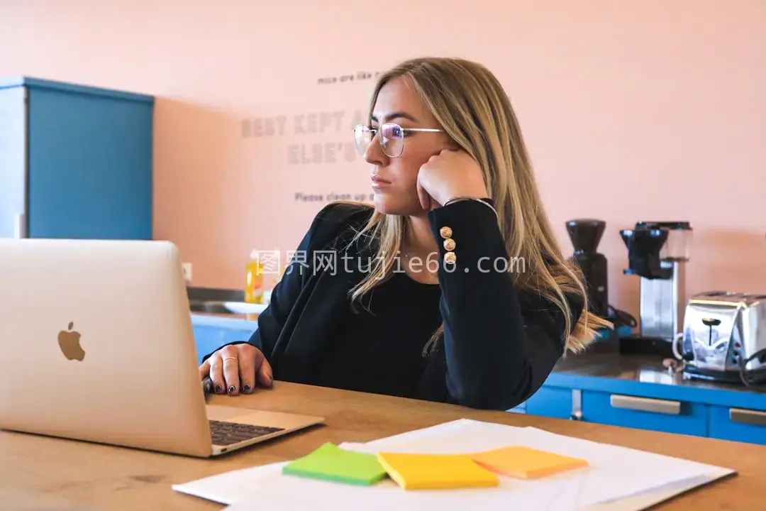 黑衣女性戴眼镜用MacBook图片