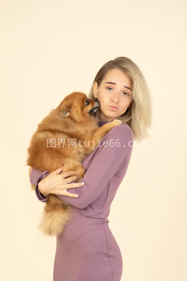 少女手持斯皮茨犬萌态十足图片