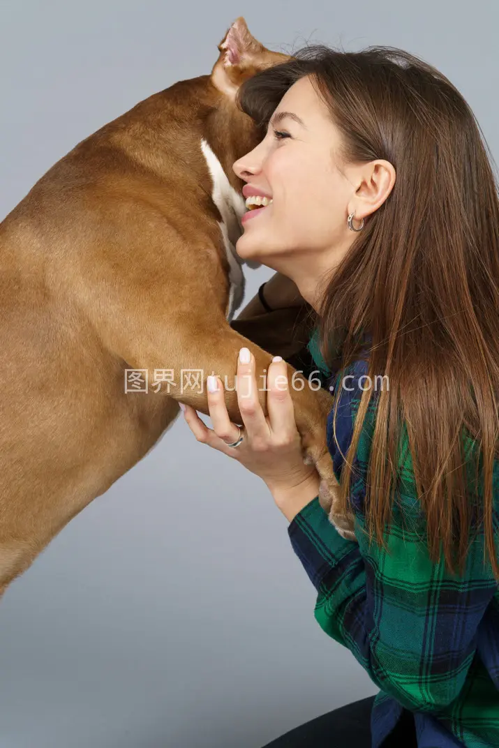 微笑女性拥抱斗牛犬图片