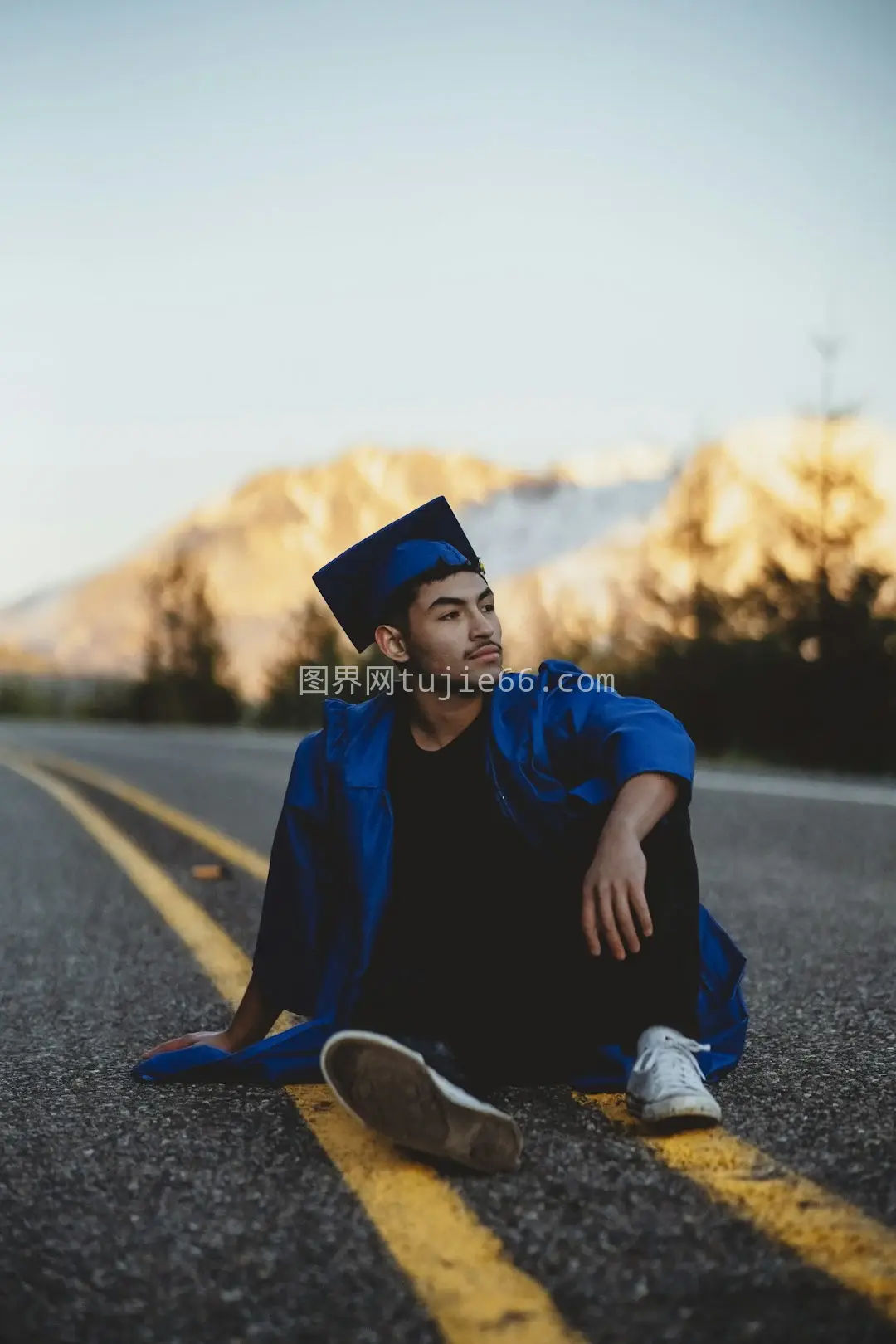 男子蓝衣黑裤白天路上静坐图片