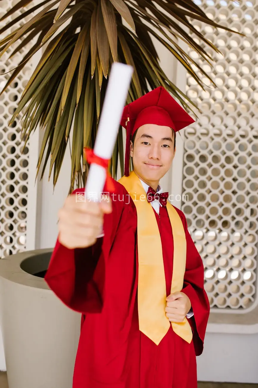 亚洲男学士服室内庆祝毕业图片