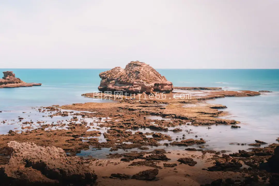 海边棕色岩石日间美景图片