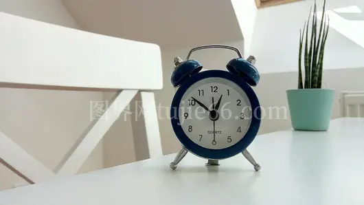 经典蓝闹钟简约桌面绿植映衬