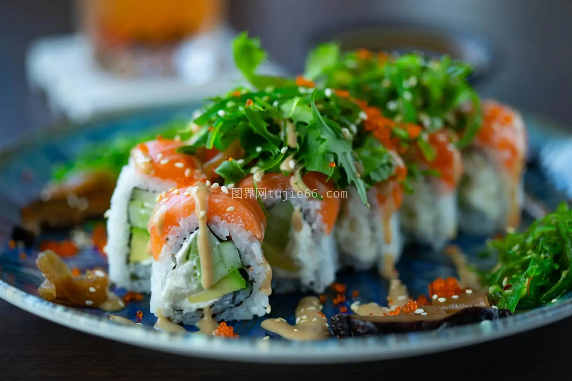 三文鱼寿司卷点缀芝麻菜酱汁装饰盘图片