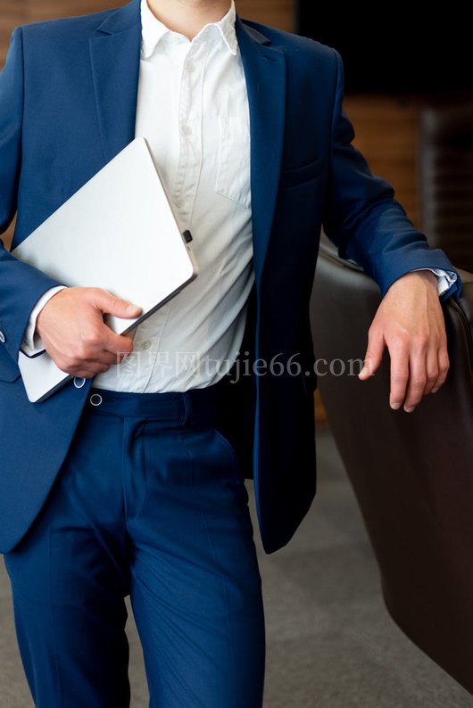 商务人士蓝西装持笔记本休闲办公