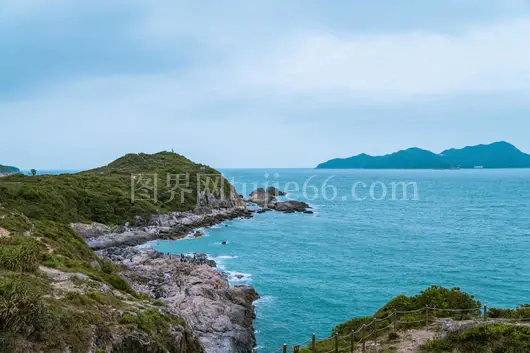 岩石海岸蓝色海洋绿丘多云