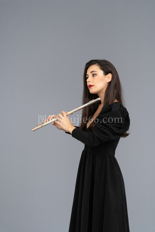 严肃年轻女士侧面黑裙持长笛
