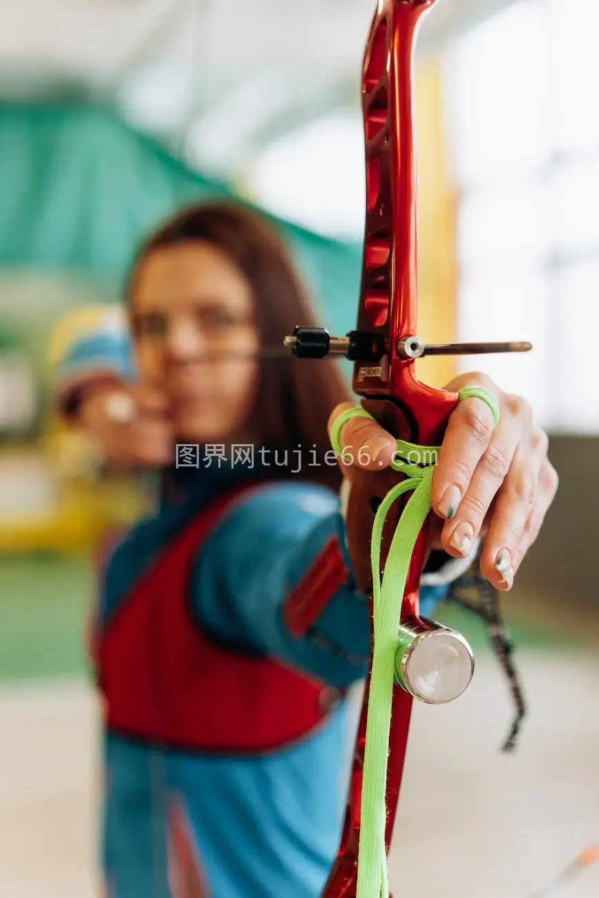 室内女射手专注精准射箭图片