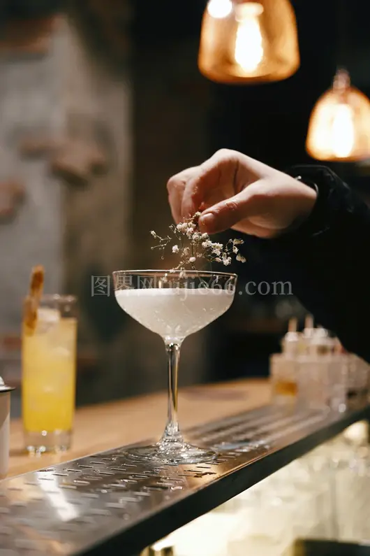 人物手握透明酒杯白液酒杯