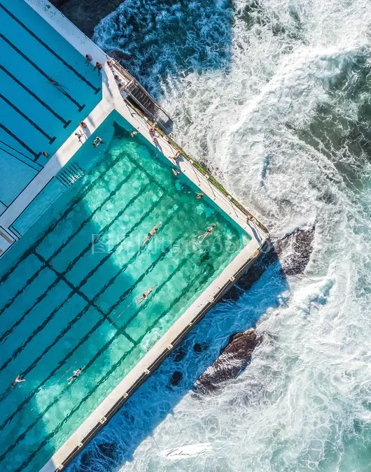 白天蓝白海洋旁蓝棕游泳池景致