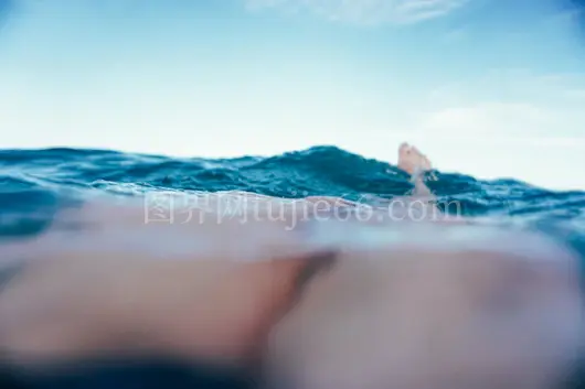 游客赤脚海面波光景度假胜地