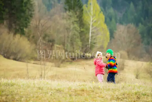 孩童冬装草地嬉戏