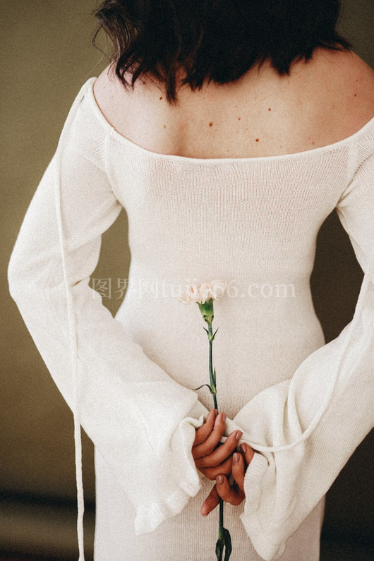 女性后视白裙握康乃馨